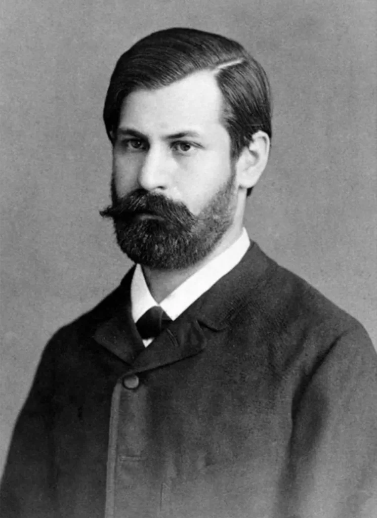 A photograph of Sigmund Freud as a young, dark-haired man in 1885.